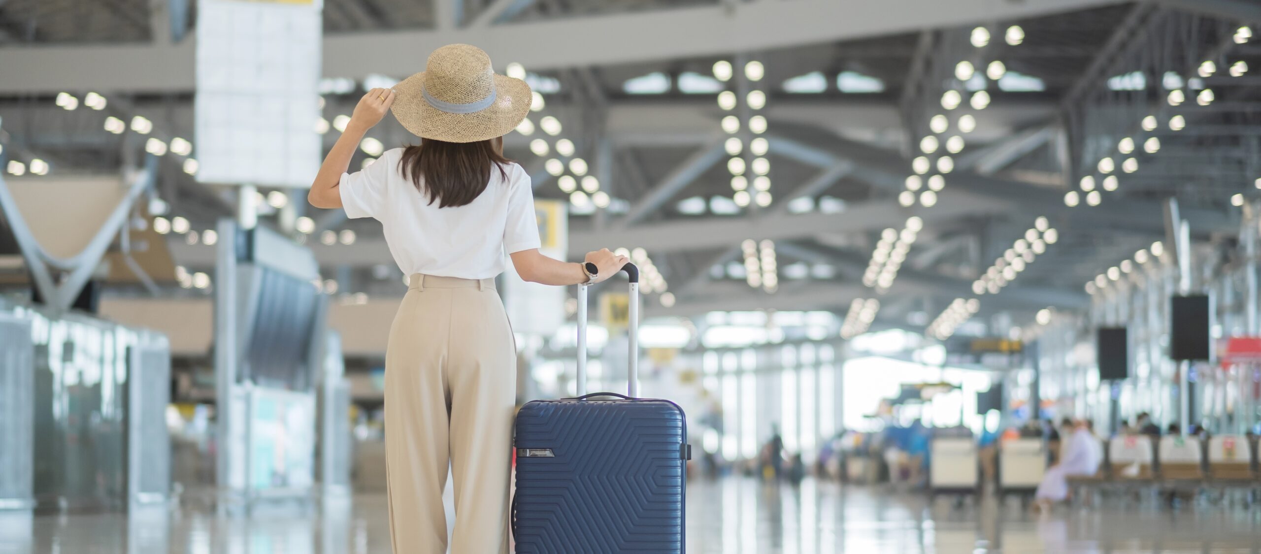 Young woman hand holding luggage handle before checking flight t