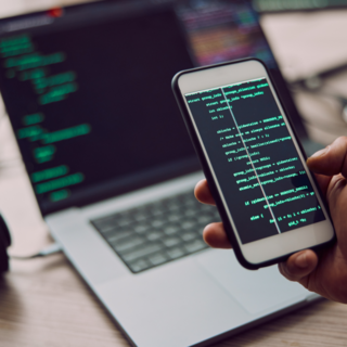 coding-laptop-and-phone-in-hand-with-man-program-2023-11-27-05-26-33-utc 1 (1)