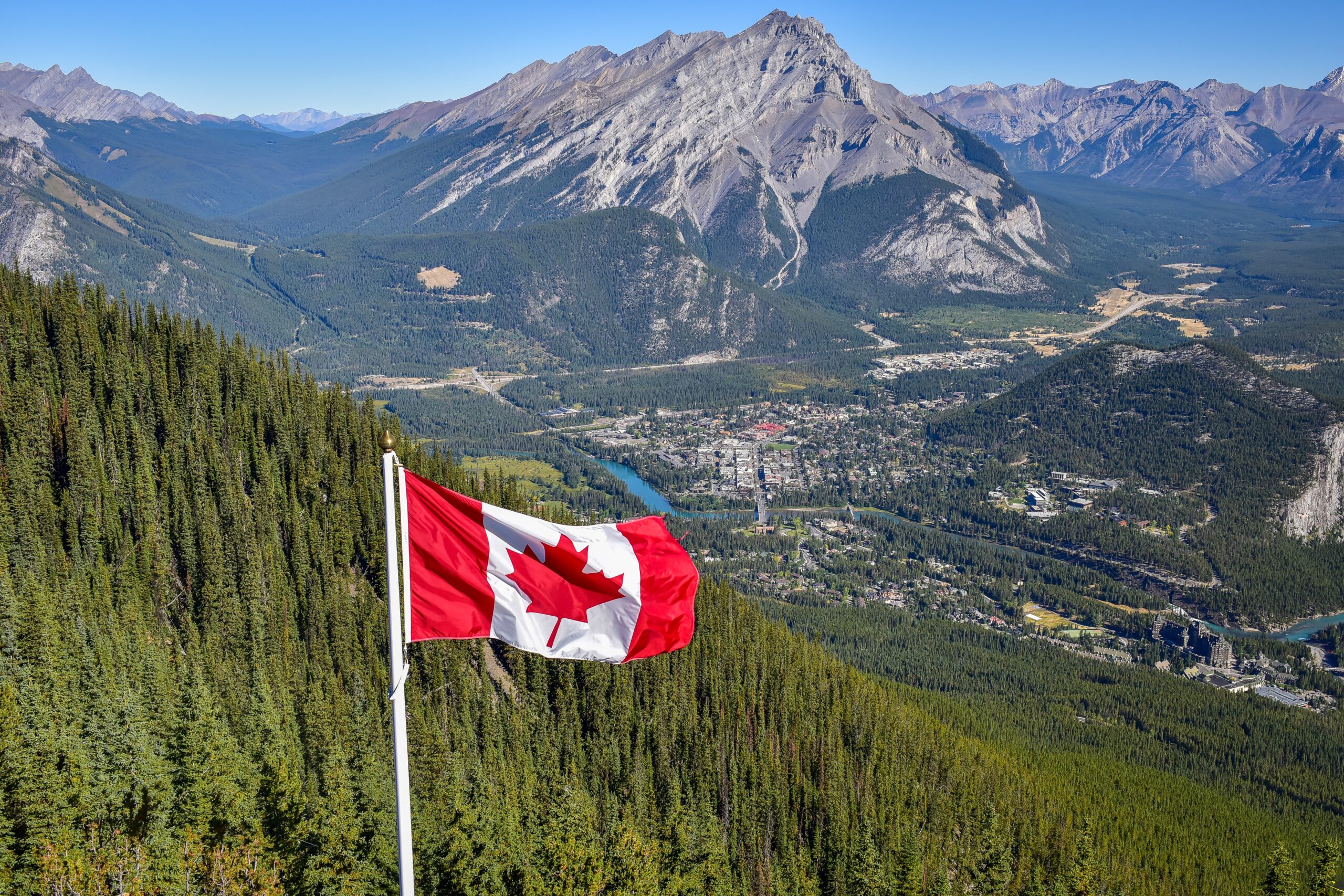 canada-flag-with-canadian-rocky-mountain-at-the-ba-2023-11-27-05-12-29-utc